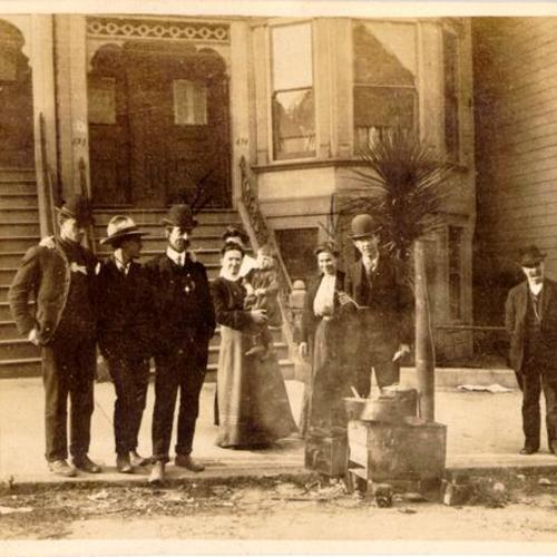 [Group of people standing by a street kitchen on an unidentified street]