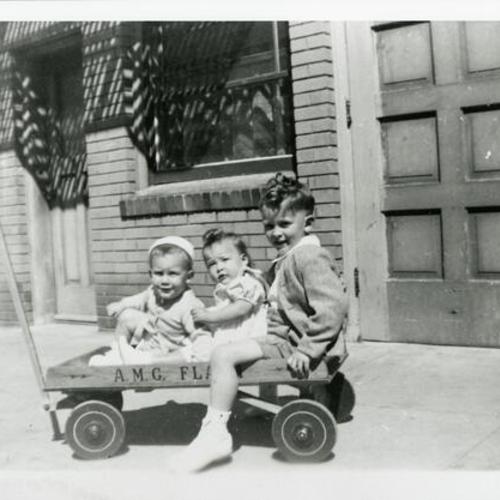 [Johnny, Julie Ann and Joey in a toy wagon on Oakwood Street]