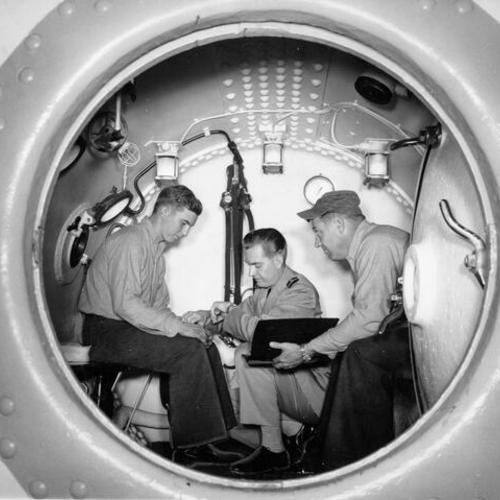 [Three men in a decompression chamber at Hunters Point Naval Shipyard]