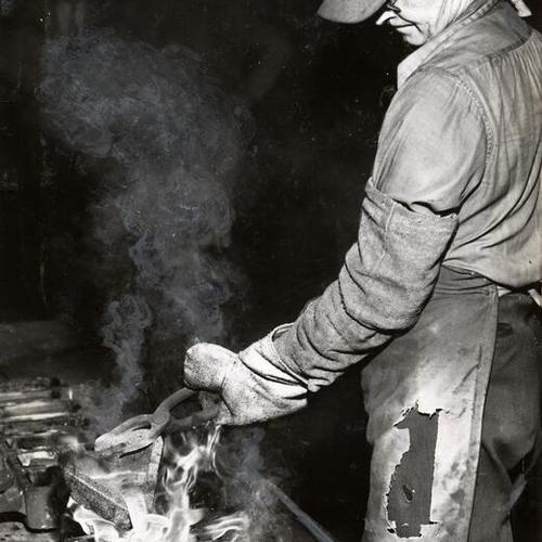 [Employee Frank Batchelor pouring silver into brick molds at the U. S. Mint in San Francisco]