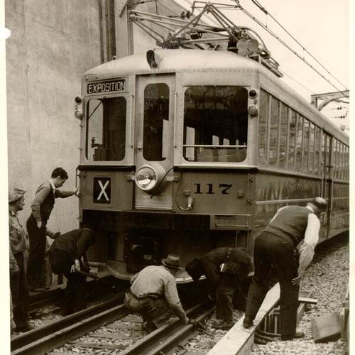 [Workers examining a San Francisco-Oakland Bay Bridge electric railway train]