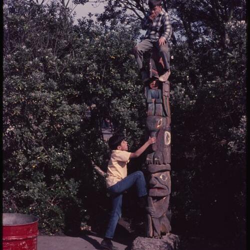 Children climbing on totem pole