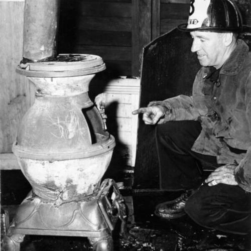 [Fire Lieutenant Jack Marlowe inspecting a stove which set off a small fire at John Swett School]