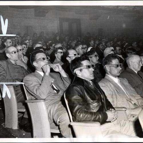 [Audience during the screening of a 3-D movie at the Orpheum Theater]