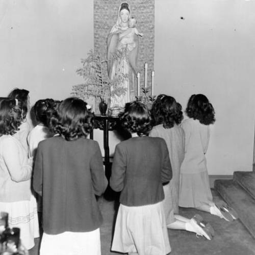 [A group of students kneeling before a statue of the Virgin Mary in the chapel of St. Mary's Parochial School]