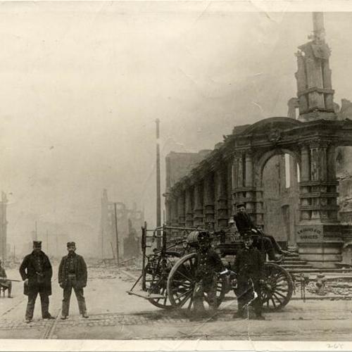 [Group of men with a fire engine in front of buildings which have been destroyed in the earthquake and fire of 1906]