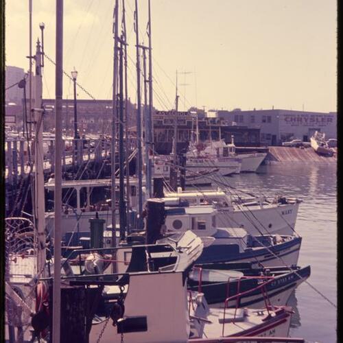 Fishing boats docked along wharf with Castagnola restaurant in background