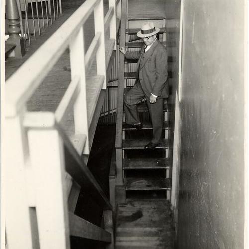 [Sheriff W.J. Fitzgerald showing wooden stairways in Ingleside jail]