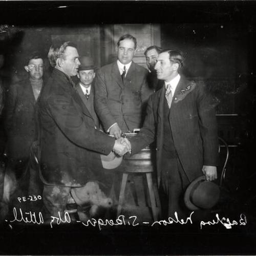 [Abe Attell (right) shaking hands with Battling Nelson (left) as Samuel Berger (center) watches]