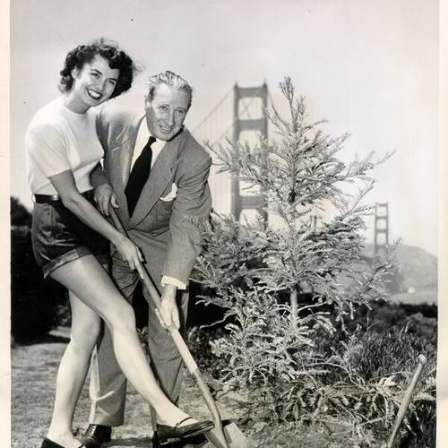 [Mildred Mersich and Joseph J. Diviny planting a redwood tree in honor of the 15th anniversary of the Golden Gate Bridge]