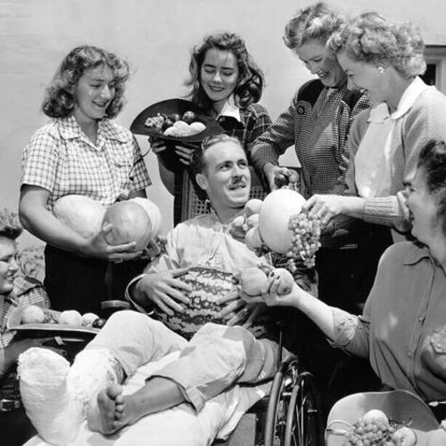 [Group of farmers' daughters presenting fruit to an Army patient at Letterman Hospital]