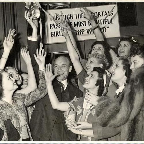 [Showman Earl Carroll surrounded by female performers inside the Geary Theater]