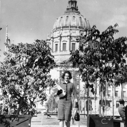 [Candis Smyk walking by rhododendron planters located at the Civic Center Plaza]