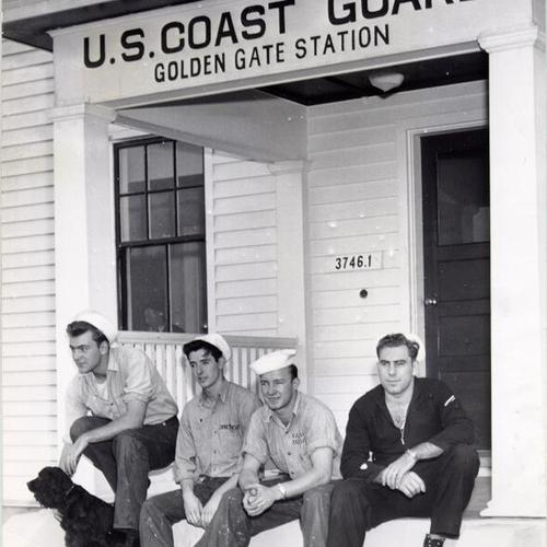 [Four Coast Guardsmen sitting on the steps of the U.S. Coast Guard Station at Ocean Beach]