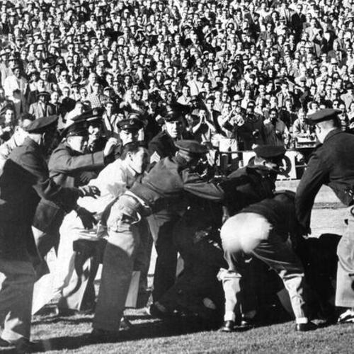 [Police trying to control unruly fans during a football game at Kezar Stadium]