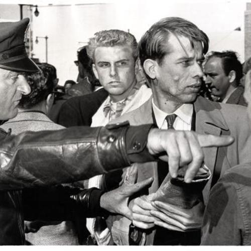 [Policeman ordering a pro-Castro demonstrator (center) to move on after he started an argument with an anti-Castro heckler before the Federal Building]