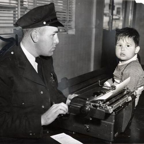 [Officer Charles McLaughlin at Mission station talking with a lost 2{u00BD} years old boy]