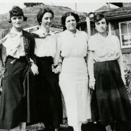 [Portrait of a four women standing in front of a home]