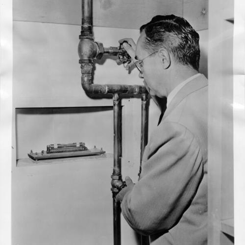[Arne Pehrson inspecting control valves at the San Francisco Airport branch of the Bank of America]