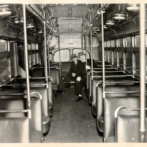 [Three unidentified men sitting at the back of a Muni bus]