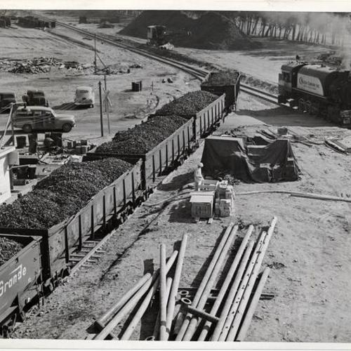 [Train cars loaded with ore at Pacific Coast's first iron and steel mill (Kaiser Steel) in Fontana]