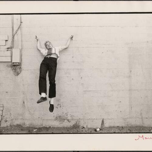 Jimmy Wilsey hanging on wall in empty lot in South of Market