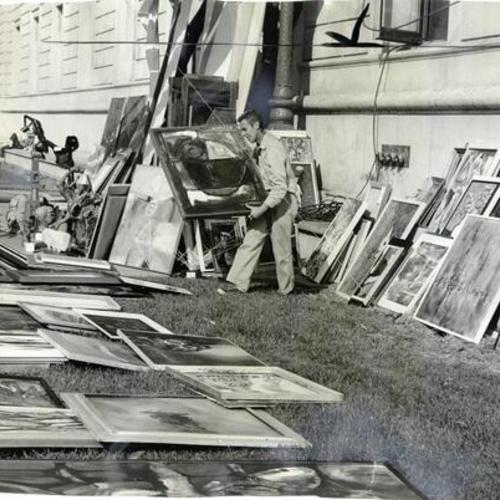 [Sidney Kittinger surrounded by an array of art work]