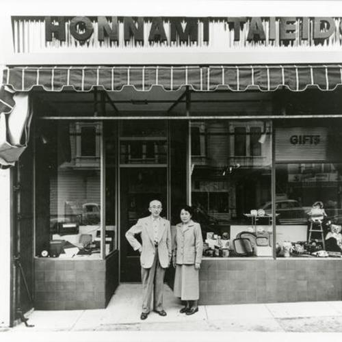[Exterior of Honnami Taieido shop with Hakoroku Henri and Suwa standing in front]