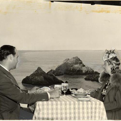 [Couple dining at the Cliff House while admiring the view of Seal Rocks]