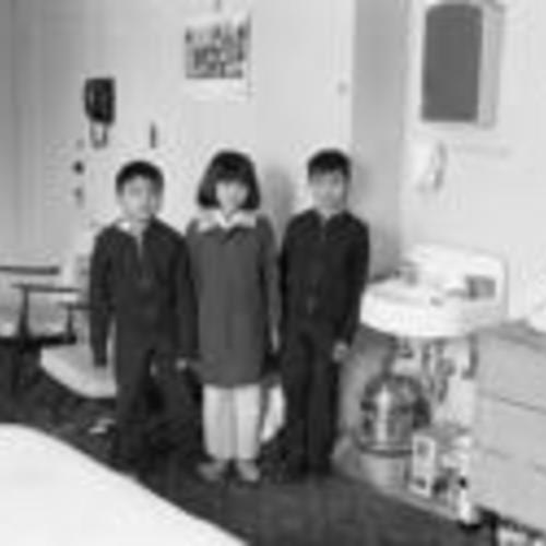 [Three children in thier family's single-room apartment in Chinatown]