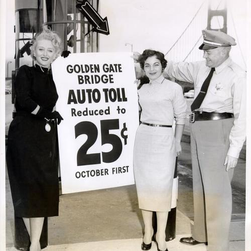 [Celeste Holm, Gale Bei, and Toll Captain Ray Logan displaying toll reduction sign]