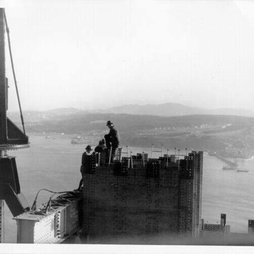 [Construction workers a top of Golden Gate bridge north tower]