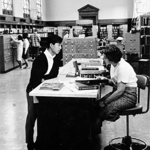 [Librarian helping a patron in the Literature Department at the Main Library]