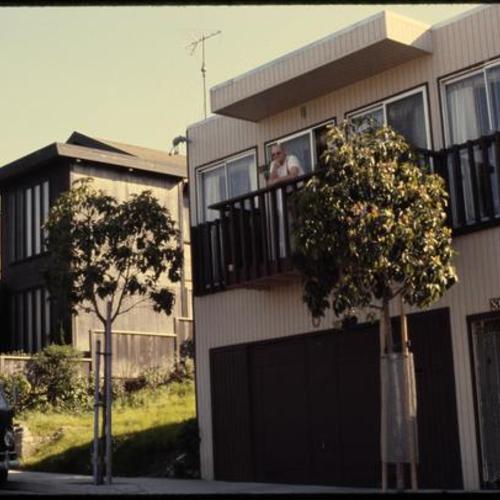 Exterior view of home with person on balcony