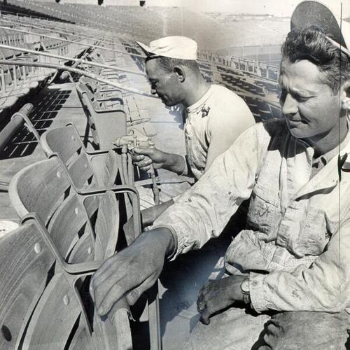 [Painters Everett Kenney and William Pope inspecting Candlestick's seats for splinters]