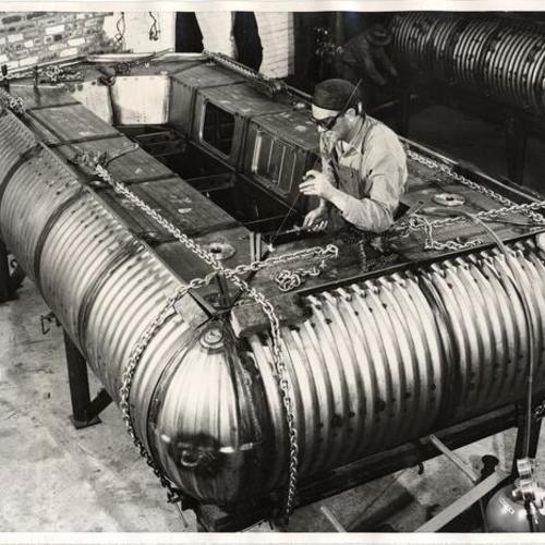 [Welder working on construction of new unsinkable life raft]
