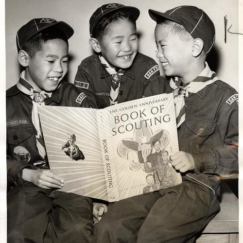 [Herb Murata, Steven Morino, and Paul Hara holding the 'Book of Scouting' special edition that honors the 50th anniversary of Boy Scouts of America]
