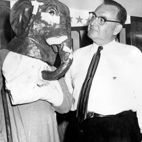 [Edmund G. (Pat) Brown and a mock-up of the "Republican elephant" at a luncheon during his campaign for governor]