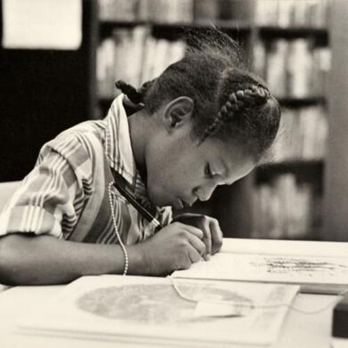 [Young girl signing an art piece inside the Bayview Branch library]
