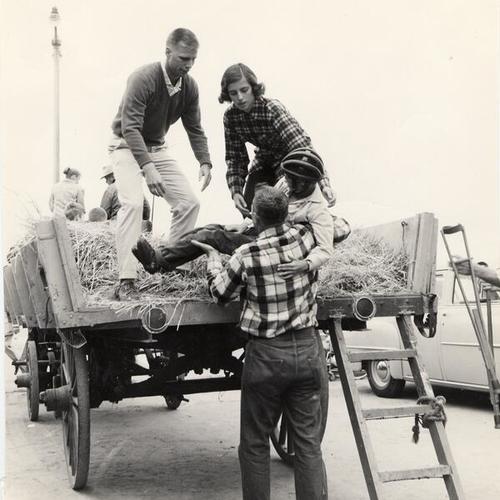 [Helping a young man onto a wagon, San Francisco Recreation Center for the Handicapped]