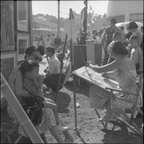 Woman and child getting charcoal portrait at the San Francisco Arts Festival