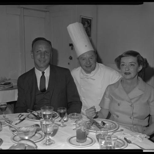 Bette Davis and people at Chef's table in St. Francis Hotel
