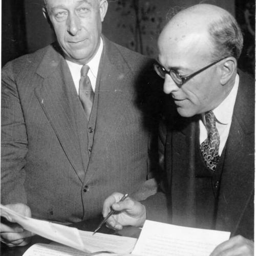 [William W. Felt and Percy E. Towner of the Golden Gate Bridge Association examine documents]