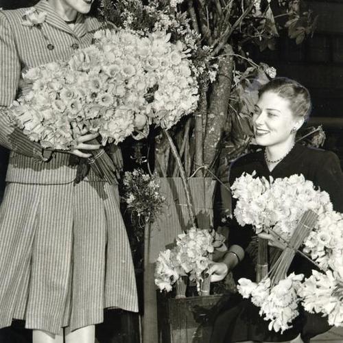 [Marge Kral and Charlotte Wansley with armloads of daffodils for the Maiden Lane festival]