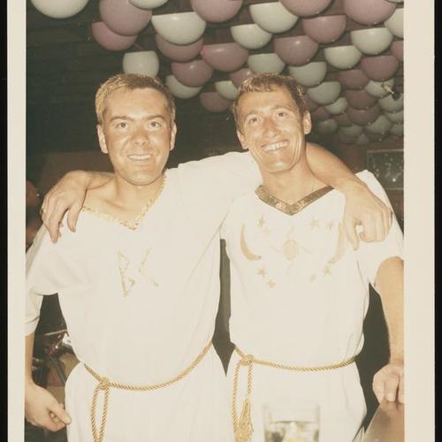 Portrait of two people in toga costumes embracing