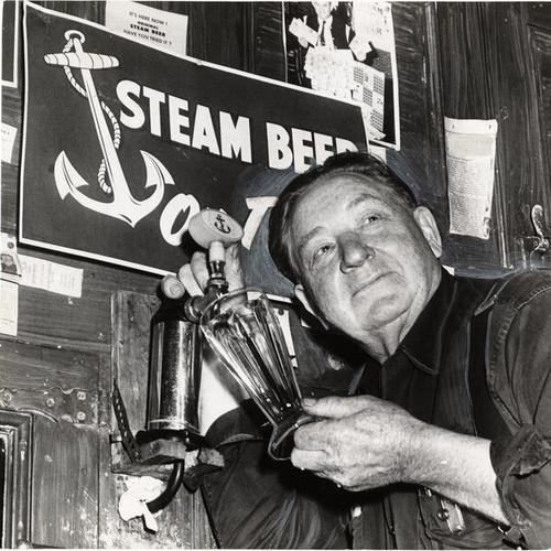 [Brewmaster Joe Allen drawing a glass of steam beer from a tap at the Anchor Brewing Company]