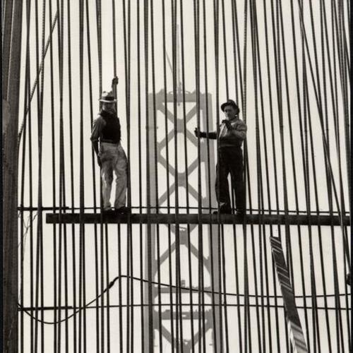 [Two workers posing with reinforcing bars during construction of the San Francisco-Oakland Bay Bridge]