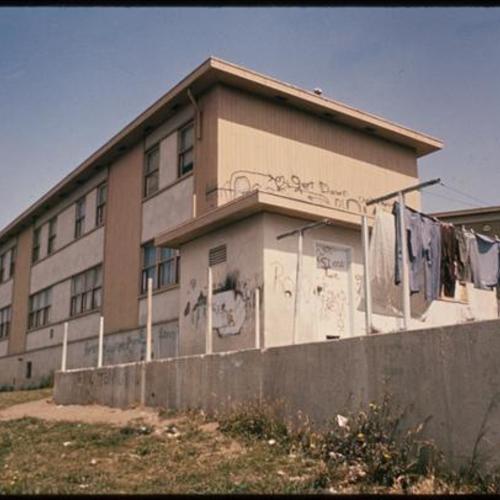 Exterior of withered building with graffiti and laundry hanging outside