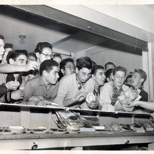 [Group of students gathered round a snack counter at Lowell High School]