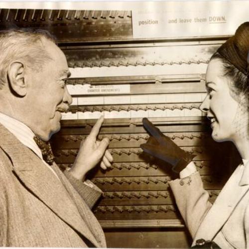 [Major Charles Collins explaining how to use a voting machine to Mrs. Louise Williams]